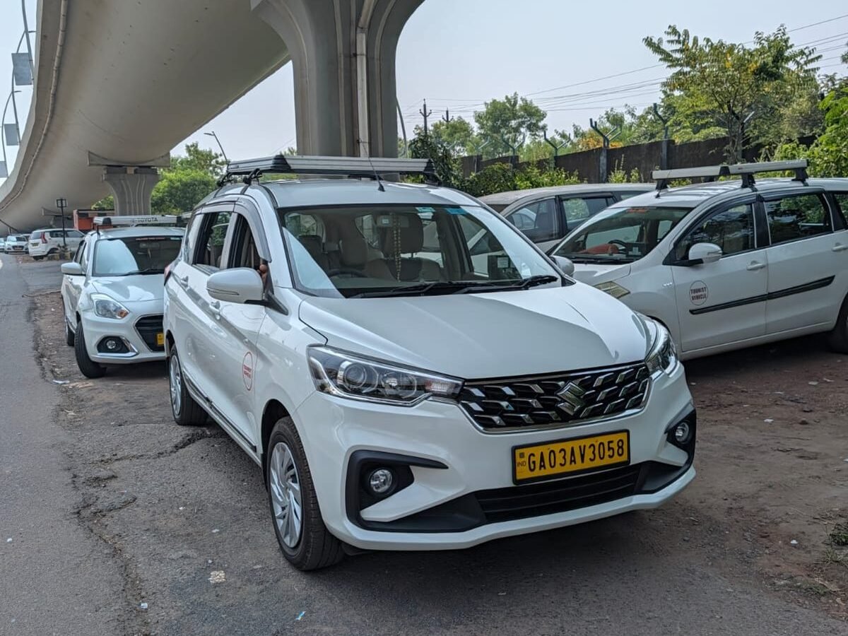 White Maruti Suzuki Ertiga taxi with roof luggage carrier near Dabolim Airport