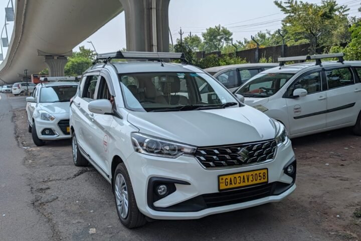 White Maruti Suzuki Ertiga taxi with roof luggage carrier near Dabolim Airport